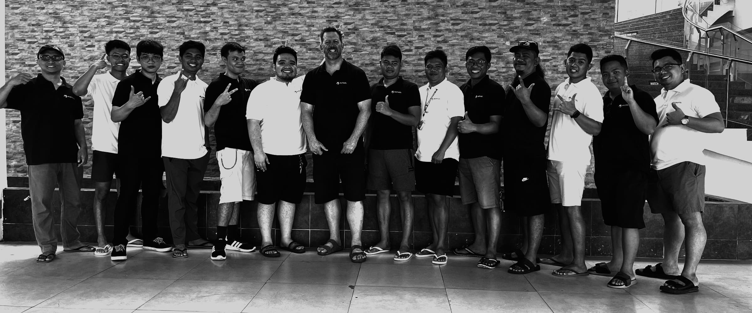 The MediaJel team lined up against a stone wall at the March 2024 team building